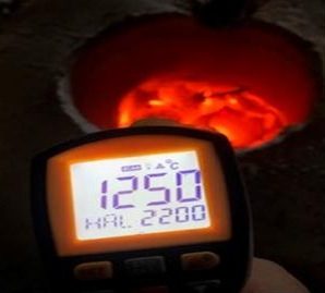 Pyromètre affichant 1250 degrés Celsius devant le four